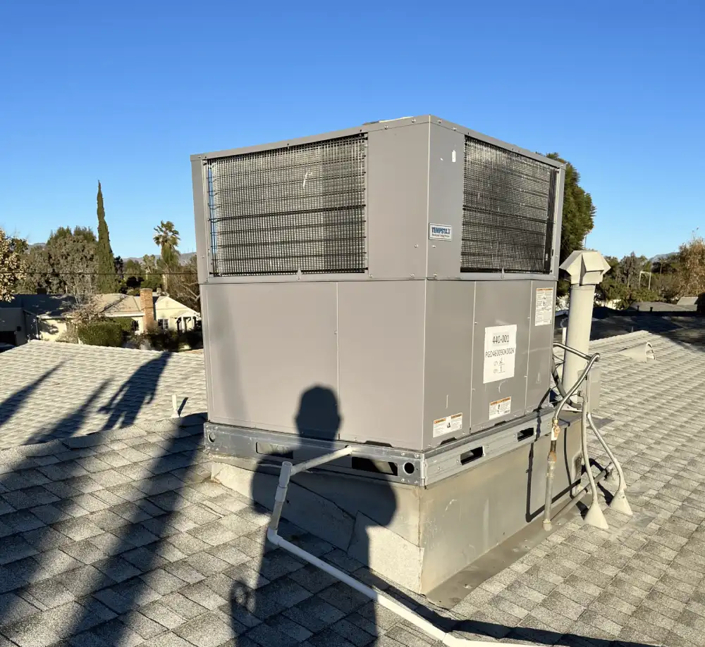 Rooftop HVAC unit installed on a residential home with shingle roofing